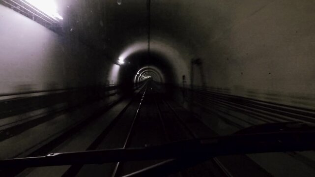 Beschleunigende U-Bahn Fahrt in beleuchtetem Tunnel aus Fahrerperspektive