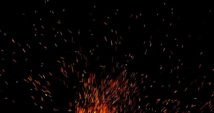 Slow motion fiery sparks flying through the air isolated on black background. Ideal as overlay effect for video editing, cinematic transitions, VFX compositing and motion graphics.