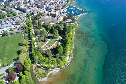Aerial view of Morges Castle and Parc de l'Independance along the shores of Lake Geneva with clear turquoise water and a small harbor Morges, Vaud, Switzerland.