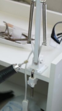 manicure and pedicure master Left-handed Technician uses electric pedicure foot file with interchangeable sanding abrasive heads to grind away rough skin on soles. Fine dead skin dust lifts off.