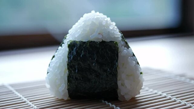 Triangular onigiri rice ball with nori seaweed wrapper, traditional Japanese snack, soft focus background with steam rising