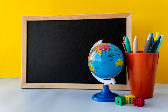 Edu content creator desk scene with blank chalkboard and globe, edutainment classroom vibe, teacher creator economy tools with colorful pens and dice, micro learning and bright studycore aesthetic