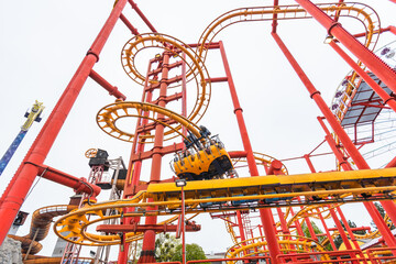 Spinning roller coaster with red supports and yellow track at Prater park in Vienna © mitarart