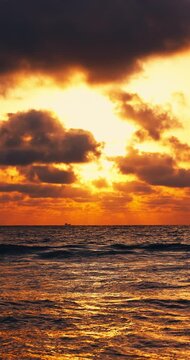 Golden sunrise over sea horizon with scenic cloudscape vertical landscape video