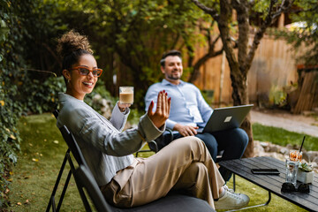 Fototapeta premium Relaxing outdoor work meeting with colleagues collaborating in garden