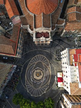 Aerial view of Teatro Massimo Bellini and the patterned pavement of the square with outdoor cafes and historic rooftops Catania, Sicily, Italy.