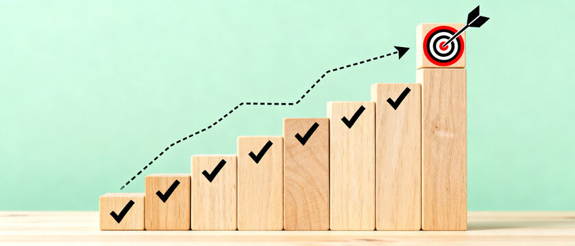 Strategic business growth concept with wooden blocks symbolizing progressive steps and milestones leading to a bullseye target, depicting successful goal achievement and planning