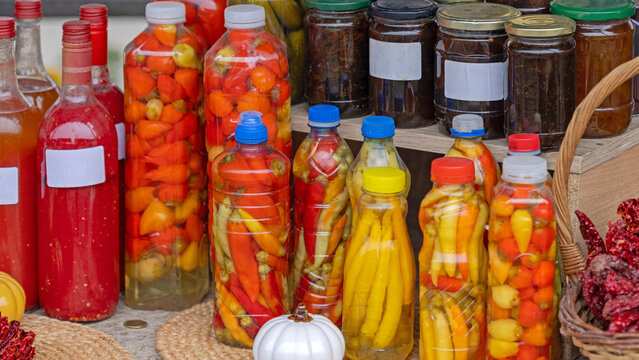 Colourful Pickled Peppers and Chilies Vegetables in Bottles Jars Food Preservation