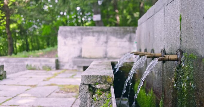 Natural spring water flowing from stone fountain near Buzludzha Bulgaria