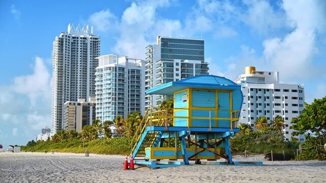 Blue and yellow iconic lifeguard tower on the sandy beach. Architectural symbols of South Beach in Miami, Florida, USA.