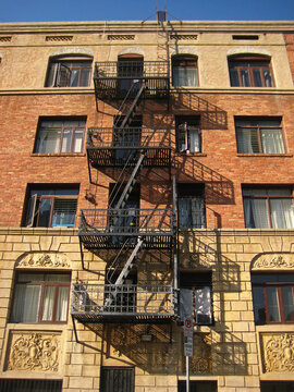 Old Building with Fire Escape and Shadows - Vertical