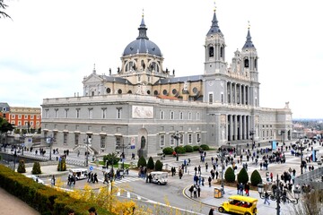 Naklejka premium The impressive Catedral de Santa María la Real de la Almudena rises majestically in the heart of Madrid, surrounded by numerous tourists ,March 15, 2026