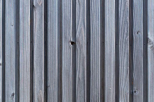Grey wooden siding texture background. Vertical timber planks wall of high-end restaurant facade. Elegant dark wood paneling backdrop. Opulent exterior cladding for luxurious fine dining establishment