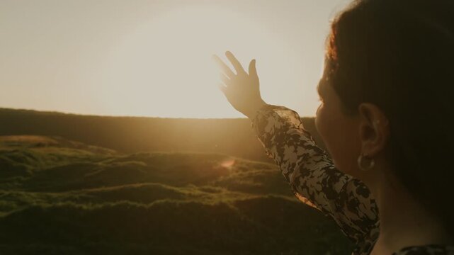 Person Reaching Hand Toward Setting Sun Over Rolling Hills, Intimate Silhouette, Warm Rim Light, Contemplative
