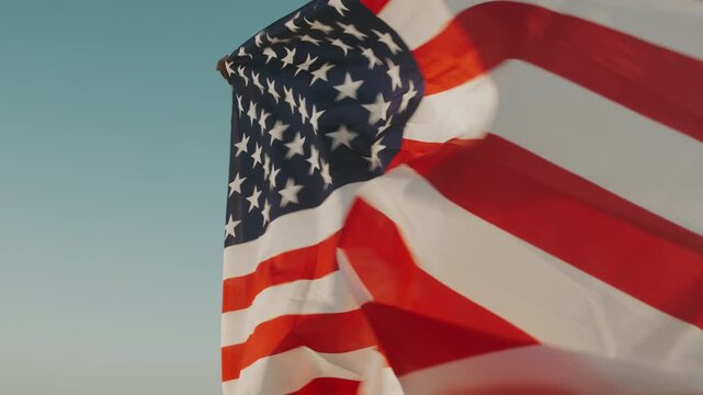 American Flag Sways Brightly. National Flag Of United States Ripples Energistically Under Clear Blue Sky