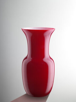 Still life of a red glass vase, on a neutral background