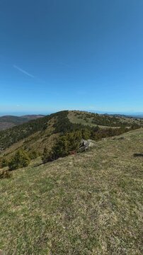 Open grassy hill under vast blue sky. Ljukten peak, (Balkans, Serbia) Vertical