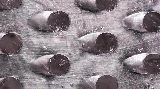 Water Stream Washing Over Metal Grater Surface, Macro Top View with Droplets and Splash Detail, Slow Motion Rinse Concept and Hygiene Action