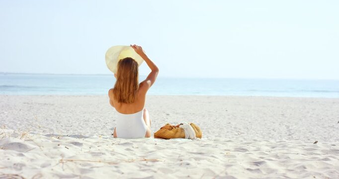 Holiday, back and woman with hat on beach for summer getaway, sunbathing and explore nature. Space, person and sunhat at seaside for tropical vacation, sightseeing destination and fresh air with view