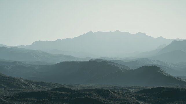 Multiple ranges of mountains and hills gradually fading into the extensive atmospheric haze, creating a serene and expansive layered landscape under a clear sky