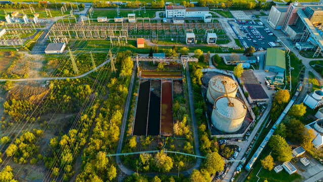 Aerial view of Malesice Infrastructure Objects featuring an electrical substation, storage tanks, and water basins surrounded by greenery in Hlavni mesto Praha, Czechia.