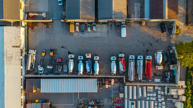 Aerial view of concrete mixer trucks and heavy machinery parked in an industrial yard with warehouses and storage materials Hlavni mesto Praha, Hlavni mesto Praha, Czechia.