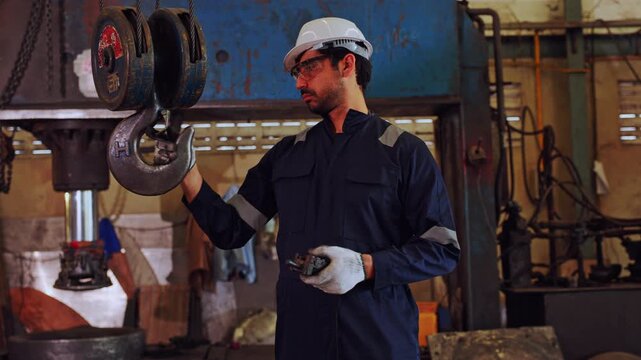 Industrial worker safety helmet protective eyewear factory workshop crane hook technician maintenance inspection inspecting heavy lifting machinery safety glove hard hat safety glasses skilled