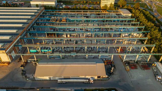 Aerial view of Malesice Infrastructure Objects featuring blue overhead cranes and stacked concrete materials under golden hour light in Hlavni mesto Praha, Hlavni mesto Praha, Czechia.