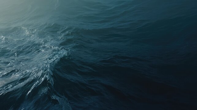Dark ocean surface with dynamic blue waves and ripples, textured liquid movement creating a moody, abstract marine background evoking energy, calm, and deep sea motion