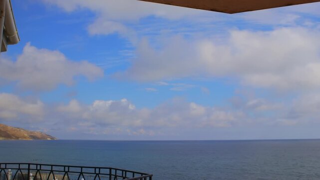 Sea View from Balcony Timelapse with Moving Evening Clouds. Coastal Balcony View with Ocean Horizon and Fast Clouds Timelapse. Evening Seaside Balcony View Timelapse with Sky and Ocean. Copy space Bac