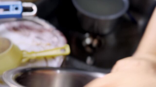 Cooking onions in kitchen on induction stove, frying chopped onions in pan during home meal preparation and everyday cooking