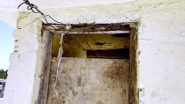 Old damaged wooden door on rooftop terrace, weathered rustic wood with peeling paint showing abandoned building architecture and decay