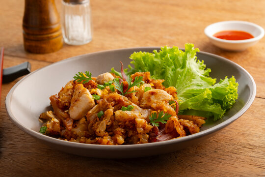 Stir fried Rice Noodles with Chicken.stir fry flat noodles with chicken ,Pickled squid and egg in a plate. (Kuay Teow Kua Gai)