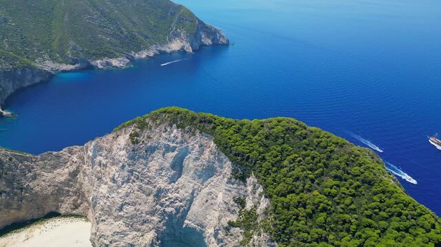 Spectacular view of the iconic Shipwreck beach in Navagio Bay, Zakynthos. Famous rusted boat on white sand surrounded by massive limestone cliffs and turquoise Ionian Sea water.