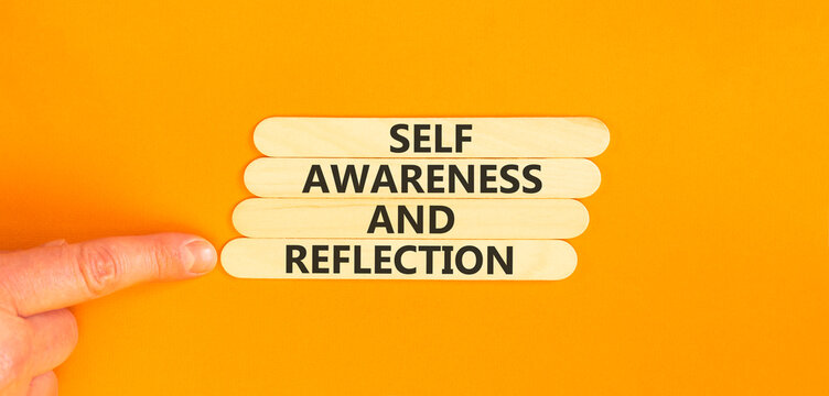 Self awareness and reflection symbol. Concept words Self awareness and reflection on beautiful wooden sticks. Beautiful orange background. Psychological self awareness reflection concept. Copy space.