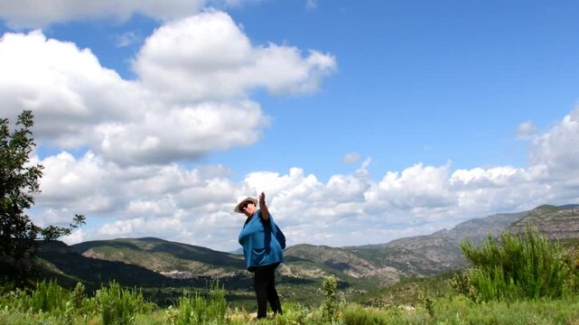 Mujer caminando por la monta&ntilde;a invit&aacute;ndote a venir.