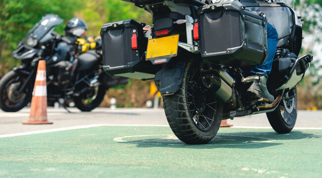 Two motorcyclists with touring bikes are stopped on a road near traffic cones, highlighting adventure and safety gear.