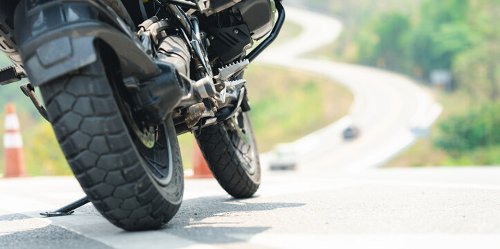 Close-up of a motorcycle tire on a winding road, emphasizing the rugged tread and adventure-ready design.