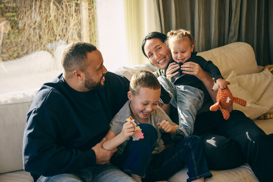 Parents spending leisure time playing with kids in living room at home