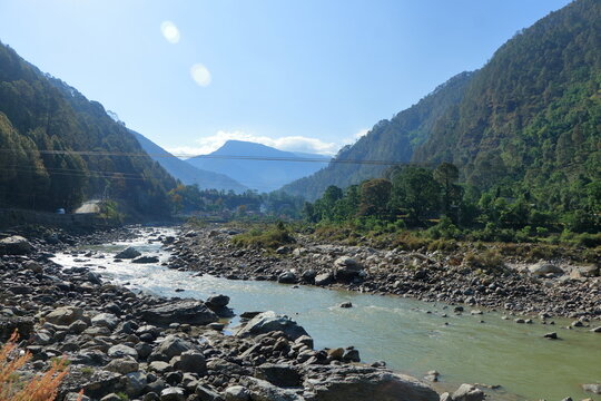 Himalayan river landscape with hillside town in Uttarkashi, Uttarakhand India.
Beautiful natural landscape of a Himalayan river flowing through a rocky valley with colorful hillside buildings, pine f