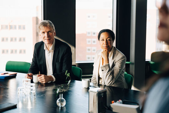 Male and female investors discussing strategies in team meeting at office