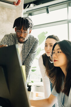 Male entrepreneur discussing strategies with female colleagues at startup workspace