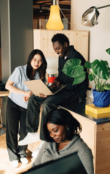 Group of diverse computer programmers working on laptop at office