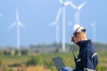 engineers working in fieldwork outdoor. Workers walking and inspect construction and machine around project site. Wind turbine electrical of clean resource enerdy and environment sustainable. © ultramansk