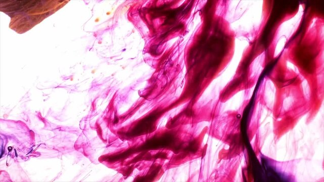Watercolor pink ink swirls with splashes and particles on white background