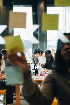 Businesswoman having brainstorm session with coworkers sitting in background