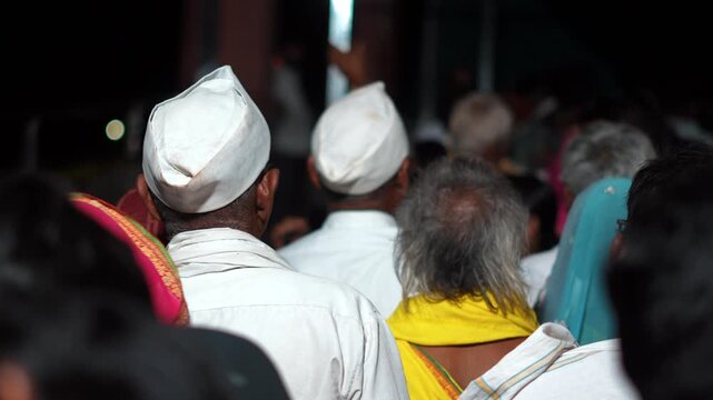 Devotees Wearing Traditional Caps at Religious Gathering