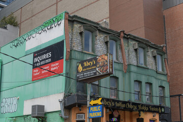 Naklejka premium exterior of historic building and sign of Abey's Indian Chinese Hakka Fusion, a restaurant, located at 118 John St, Toronto