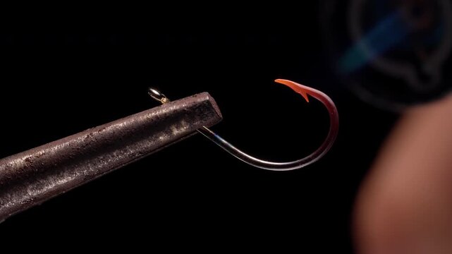 Heated Fishing Hook Cooling from Red Glow to Metal Surface While Held in Tool, Macro Close Up on Black Background, Slow Motion Temperature Control and Material Stability