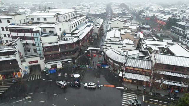 Snowy aerial view of traditional Chinese town streets and rooftops